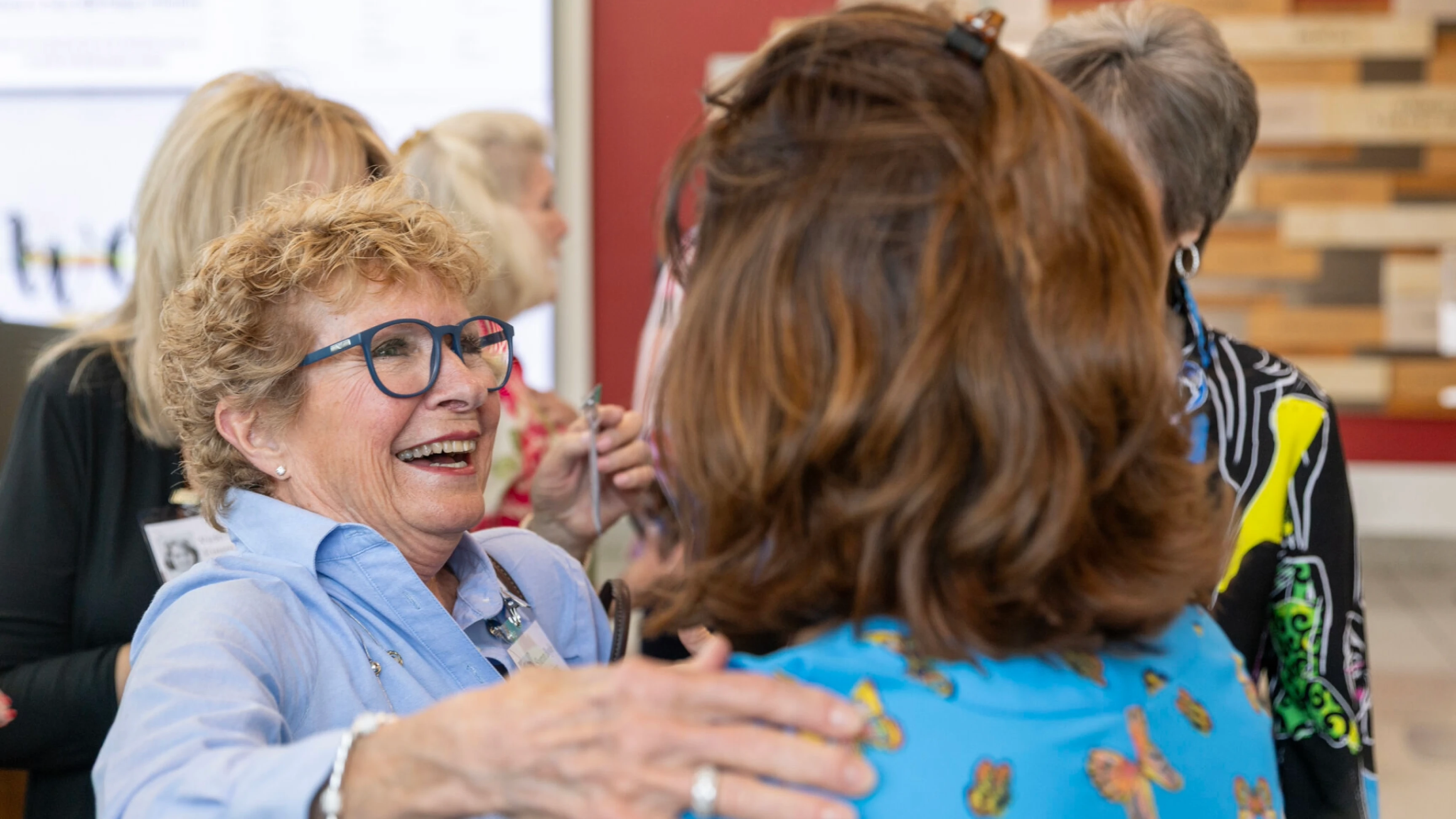 Dental hygiene program alumni hug a classmate during a reunion.