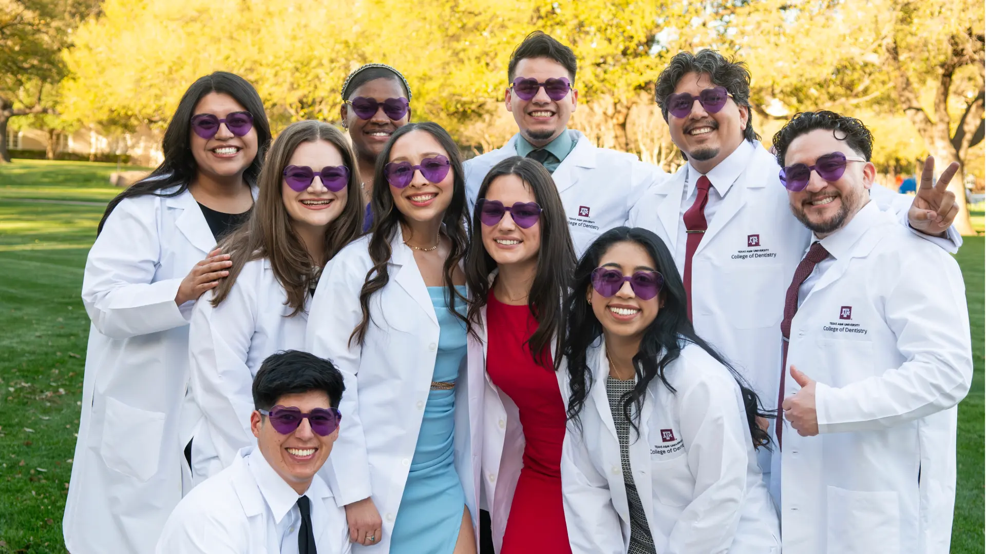 Dental students in white lab coats and sunglasses.