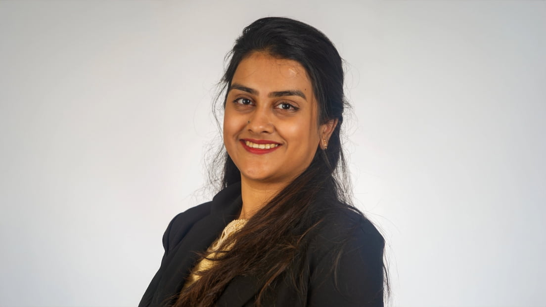 Profile headshot of Prajakta Chaudhari smiling against a gray background.